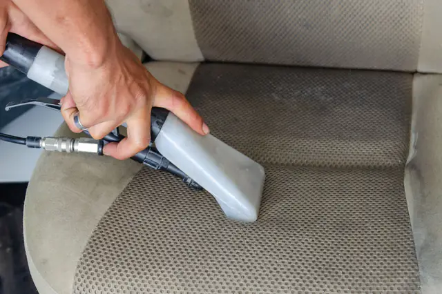A hot water extractor being drawn across a fabric car seat
